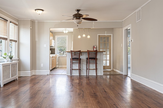 dining space featuring wood-type flooring, plenty of natural light, radiator, and ornamental molding