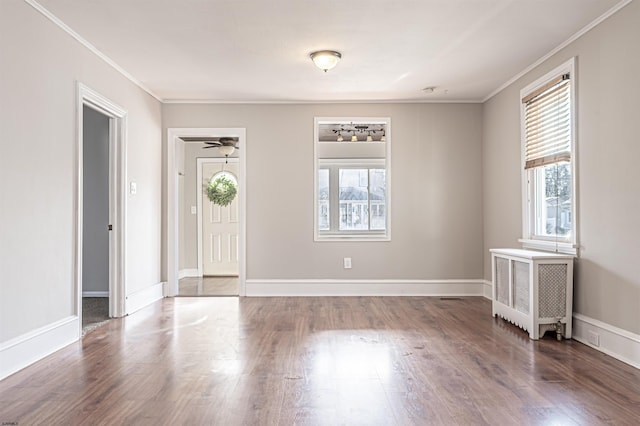 foyer featuring radiator heating unit, ornamental molding, dark hardwood / wood-style floors, and a healthy amount of sunlight