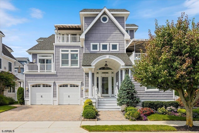 view of front of home with a garage and a balcony