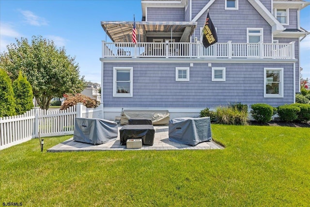 back of house featuring a balcony, a yard, and a patio