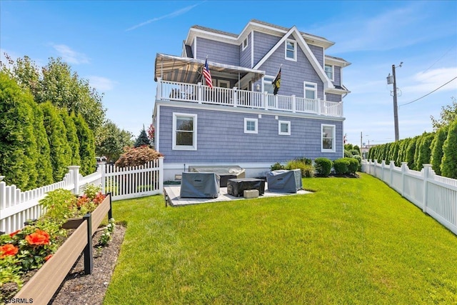 back of property with a fire pit, a yard, and a patio area