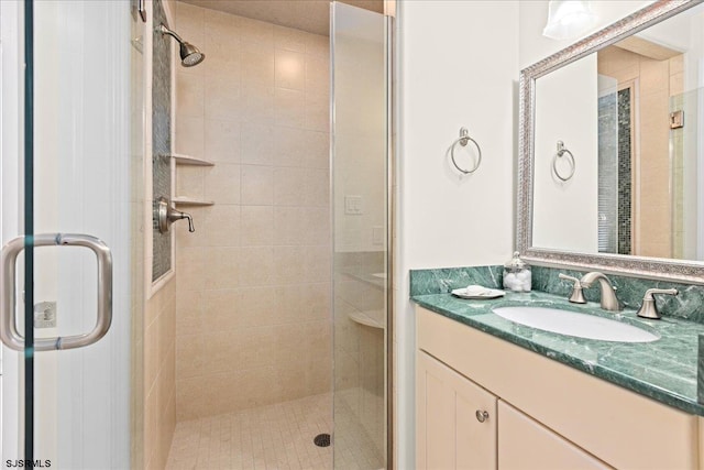 bathroom with a shower with door and vanity