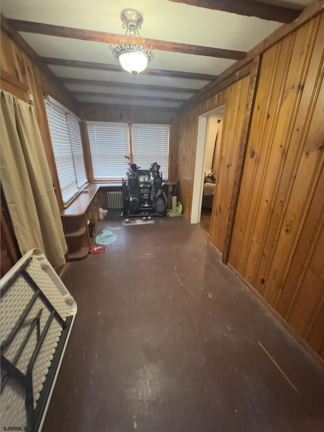 misc room with radiator heating unit, wooden walls, and beam ceiling