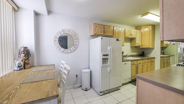 kitchen featuring light tile patterned flooring, white appliances, light brown cabinetry, and sink