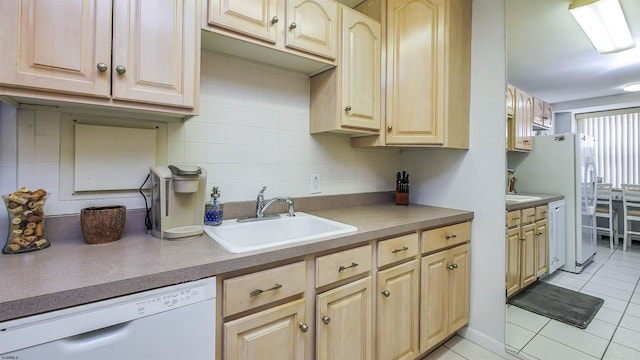 kitchen with light tile patterned flooring, light brown cabinetry, sink, white appliances, and decorative backsplash