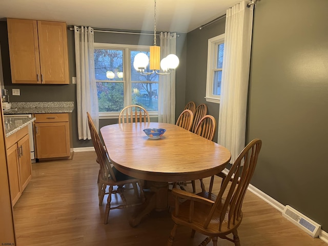 dining room with an inviting chandelier and light wood-type flooring