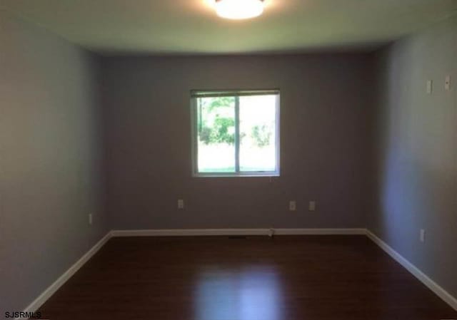 spare room featuring dark wood-type flooring