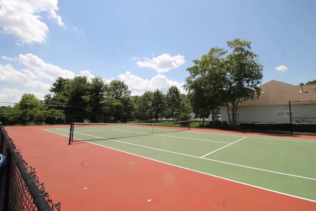 view of tennis court with community basketball court and fence