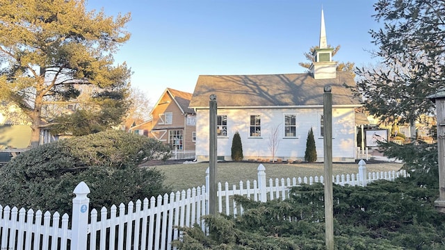 cape cod house with a fenced front yard