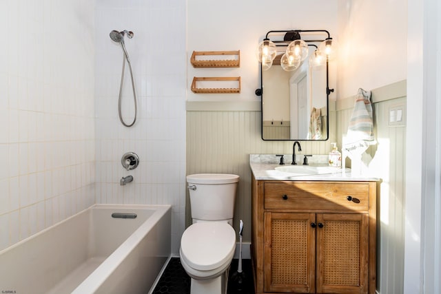 full bathroom featuring vanity, tiled shower / bath combo, and toilet