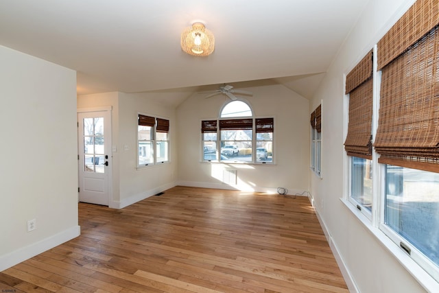 unfurnished living room featuring lofted ceiling, ceiling fan, and light wood-type flooring