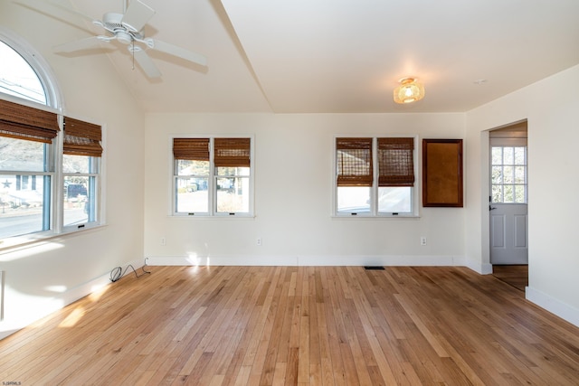 spare room featuring ceiling fan, lofted ceiling, a wealth of natural light, and light hardwood / wood-style floors