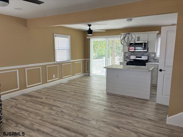 kitchen with white cabinetry, ceiling fan, appliances with stainless steel finishes, and hanging light fixtures