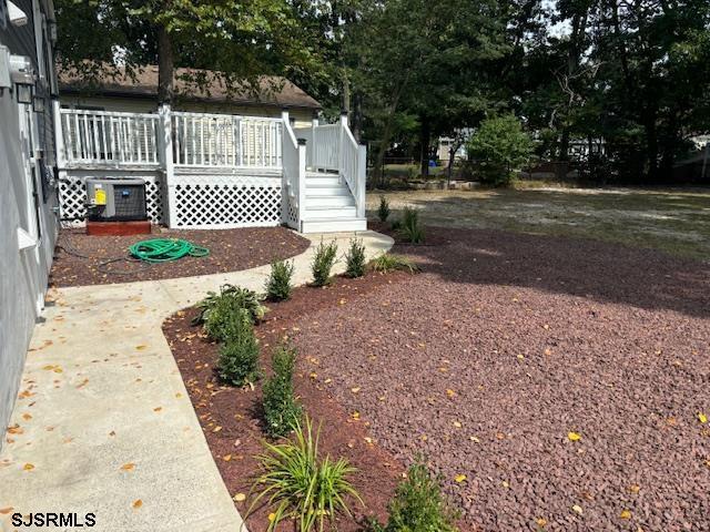 view of yard featuring a wooden deck and central AC unit