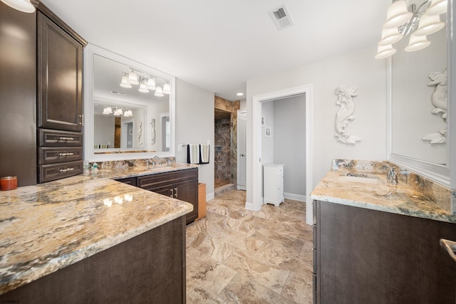 bathroom featuring tiled shower and vanity