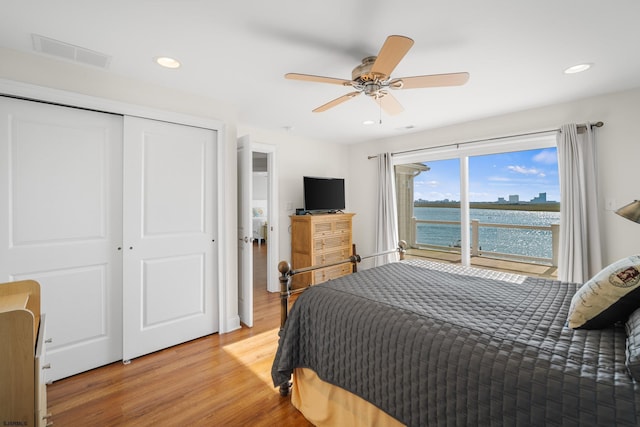 bedroom with light hardwood / wood-style floors, a closet, and ceiling fan