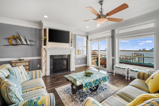 living room featuring crown molding, dark wood-type flooring, ceiling fan, and a fireplace