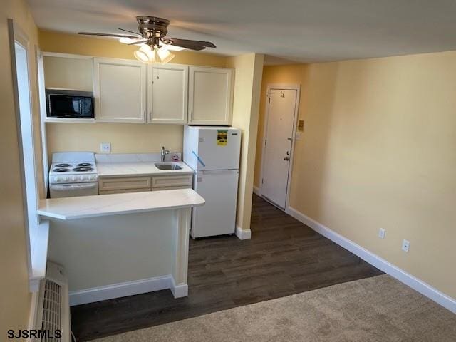 kitchen with sink, white cabinetry, ceiling fan, dark hardwood / wood-style floors, and white appliances