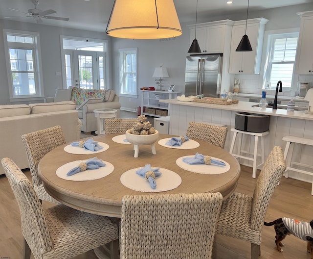 dining area with ceiling fan, sink, and light hardwood / wood-style floors