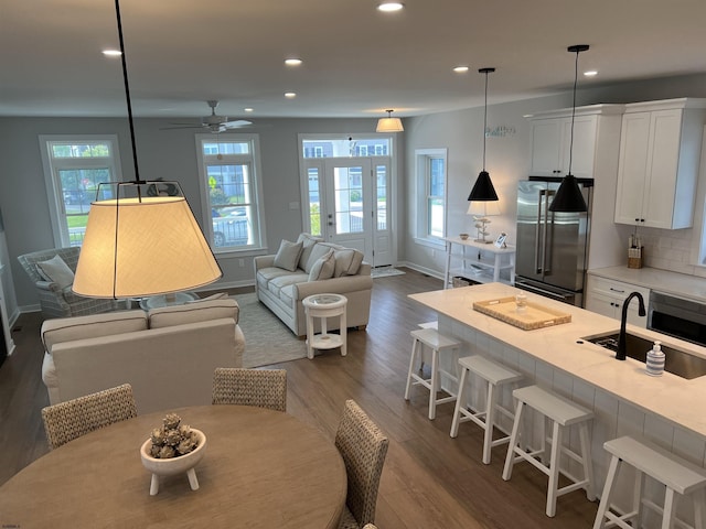 living room with ceiling fan, sink, and dark hardwood / wood-style flooring