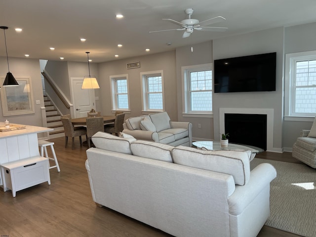 living room with dark wood-type flooring and ceiling fan