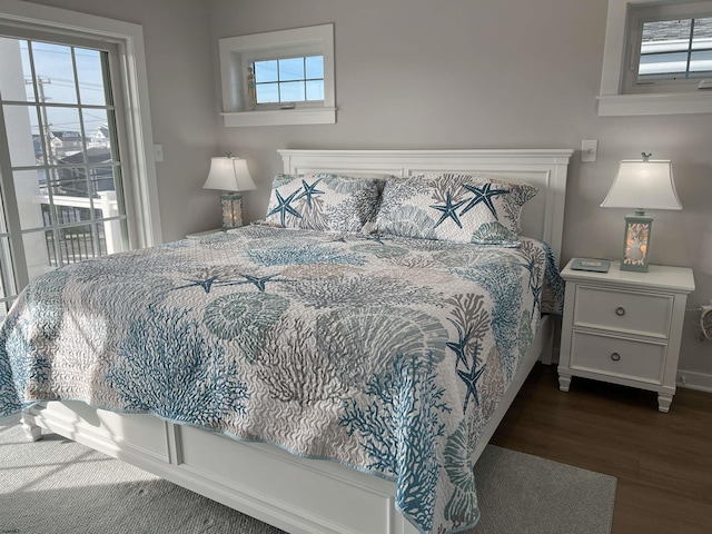 bedroom featuring dark hardwood / wood-style flooring and multiple windows