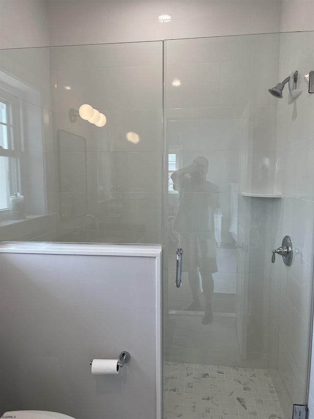 bathroom with toilet and a shower with shower door