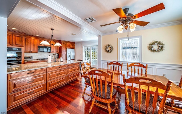 dining space featuring dark wood-type flooring, ceiling fan, crown molding, and sink