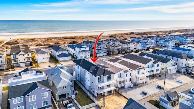 bird's eye view featuring a water view and a beach view