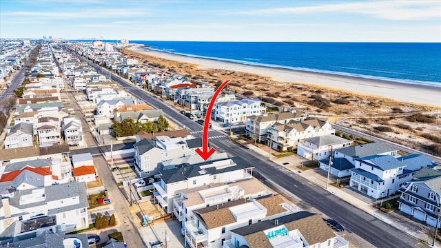 drone / aerial view featuring a water view and a beach view