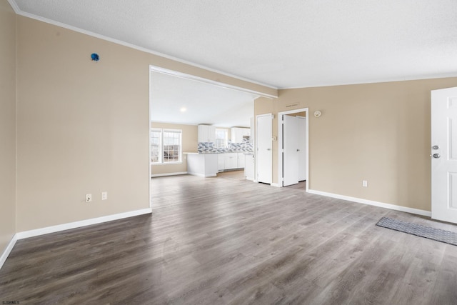 unfurnished living room featuring crown molding, lofted ceiling with beams, a textured ceiling, and light wood-type flooring