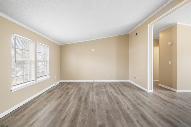 empty room with crown molding, a textured ceiling, and light hardwood / wood-style flooring