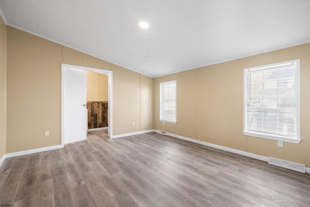 spare room with light hardwood / wood-style floors and vaulted ceiling