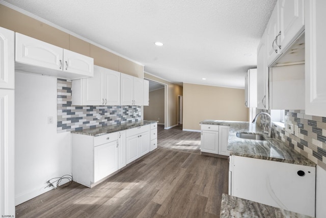 kitchen featuring dark hardwood / wood-style flooring, sink, dark stone counters, and white cabinets