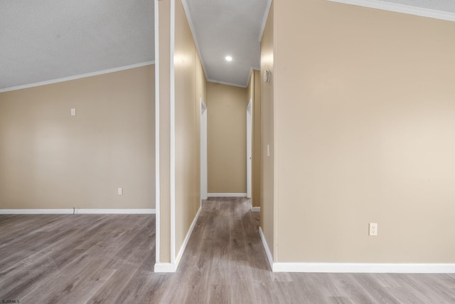 hall with ornamental molding and light hardwood / wood-style floors