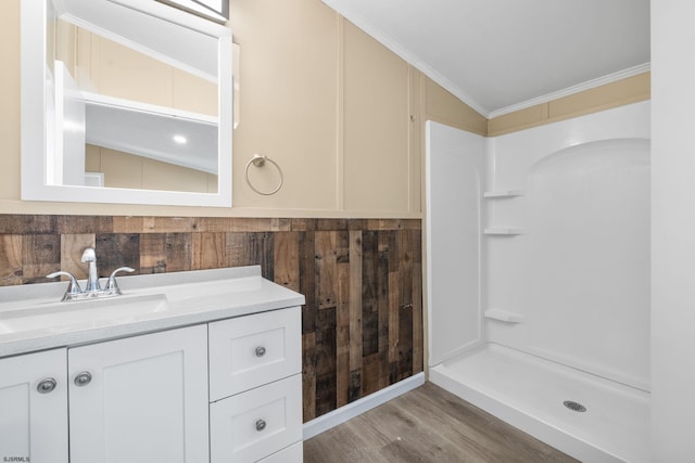 bathroom with crown molding, vanity, wood-type flooring, a shower, and wood walls