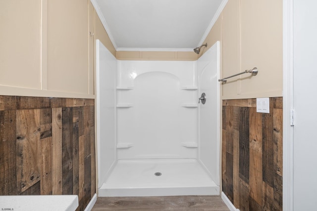 bathroom with ornamental molding, a shower, and hardwood / wood-style floors