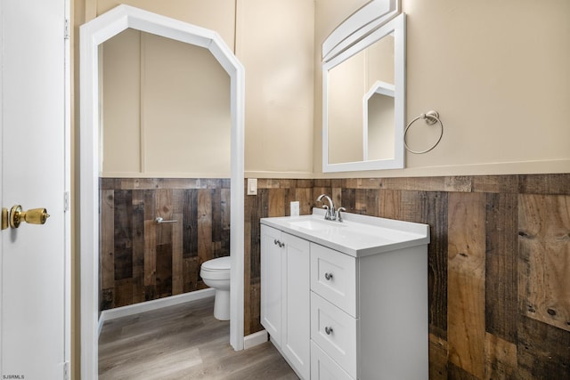 bathroom with hardwood / wood-style flooring, vanity, and toilet