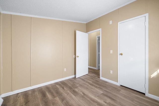 unfurnished bedroom with ornamental molding and light hardwood / wood-style floors