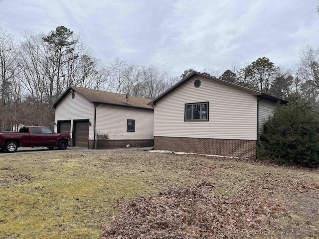 view of side of property featuring a yard and a garage