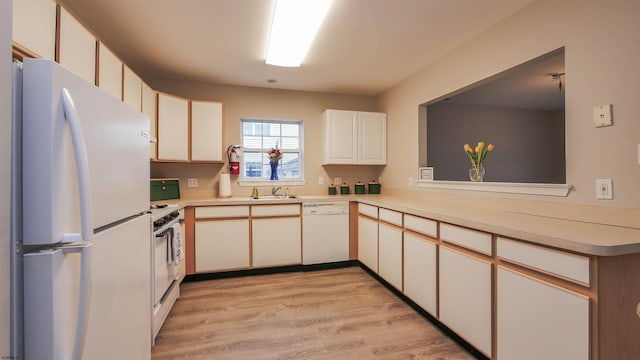 kitchen with sink, white appliances, light hardwood / wood-style flooring, and white cabinets