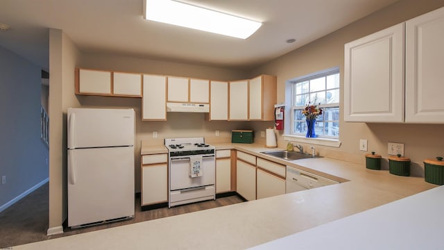 kitchen featuring sink, white appliances, white cabinetry, dark hardwood / wood-style floors, and kitchen peninsula