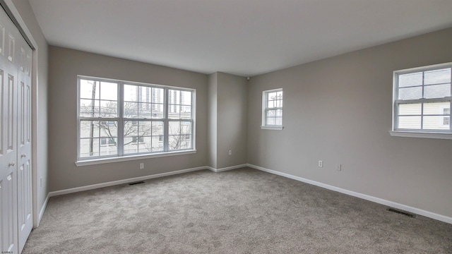 unfurnished room featuring light carpet