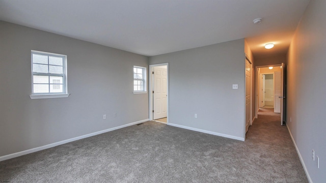 unfurnished bedroom with carpet and multiple windows