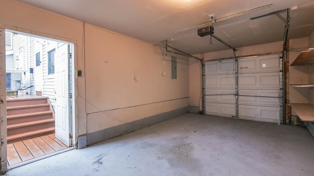 garage with a garage door opener and electric panel