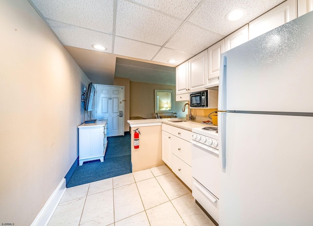 kitchen featuring white cabinetry, sink, kitchen peninsula, a drop ceiling, and white appliances