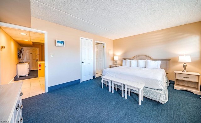 bedroom featuring dark colored carpet and a textured ceiling