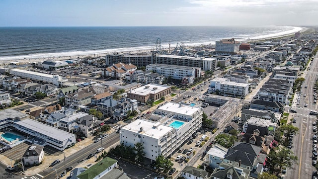 birds eye view of property with a water view and a beach view