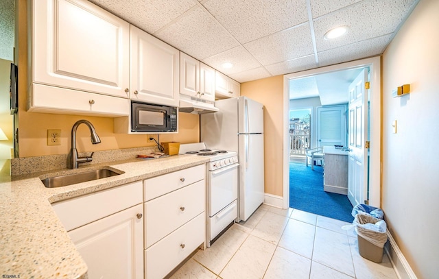 kitchen with sink, white appliances, light stone countertops, and white cabinets