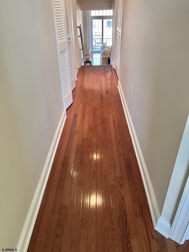 corridor with hardwood / wood-style flooring